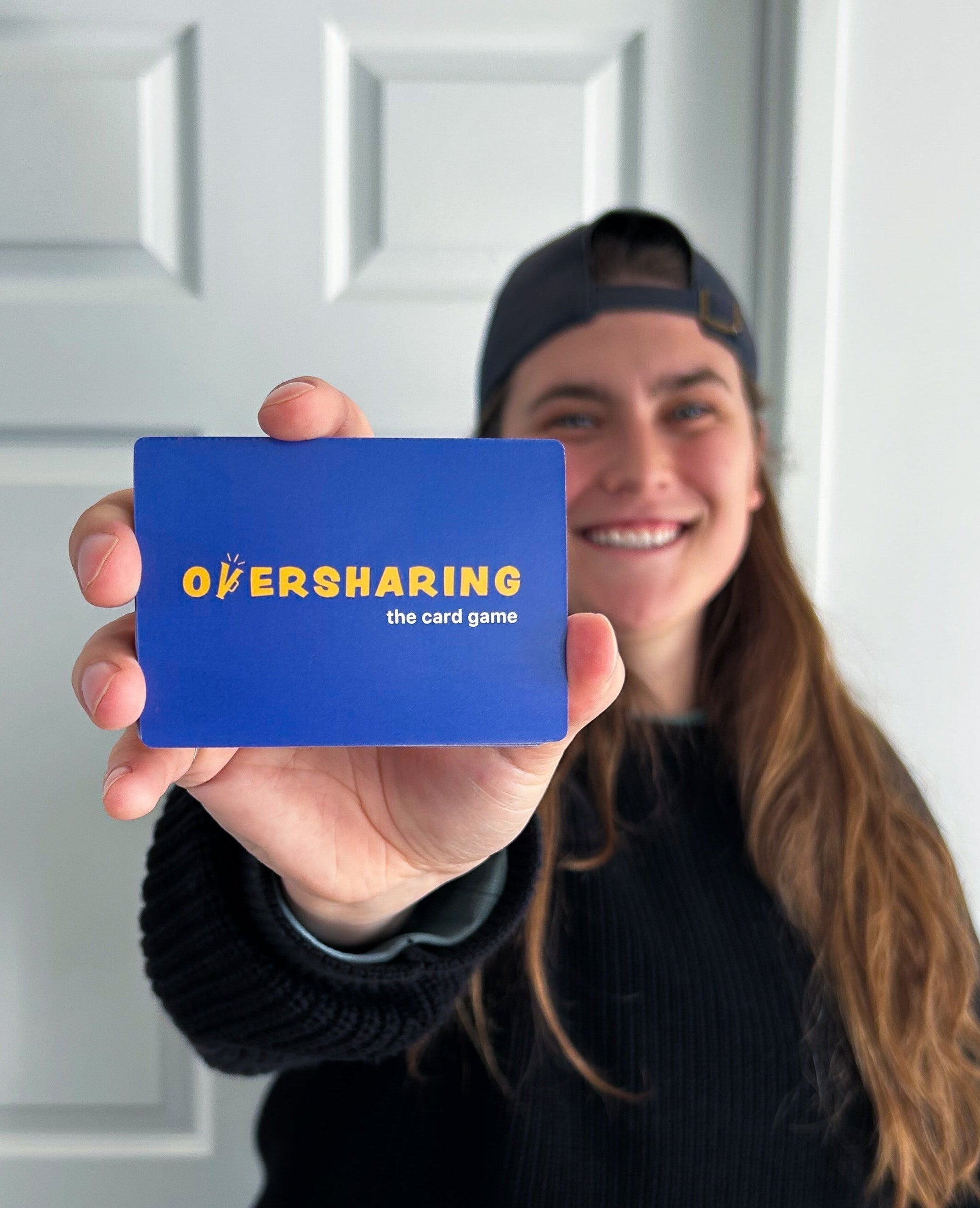 Oversharing owner holding deck of Oversharing cards.